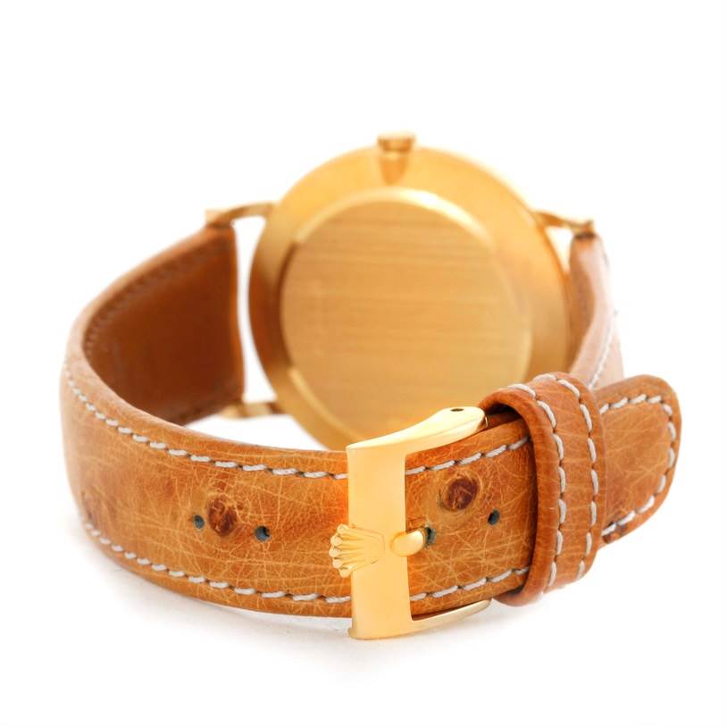 The image shows the back view of a Rolex Cellini 5112 Men's Yellow Gold Beige Dial 5112 Men's Yellow Gold Beige Dial watch focusing on the gold case and tan leather strap with a gold buckle.