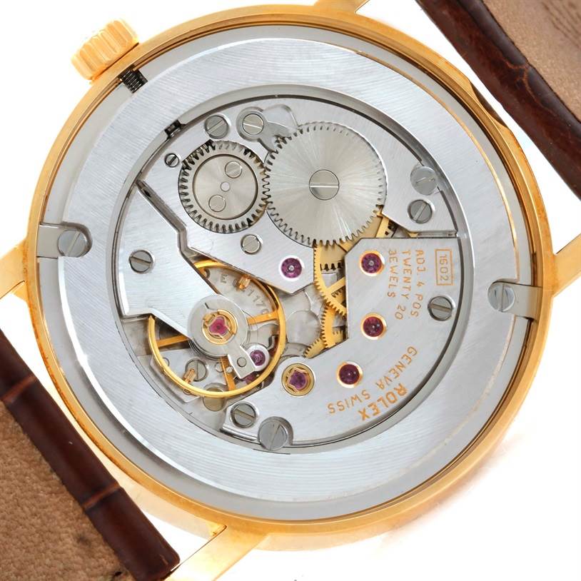 The image shows the intricate inner mechanism of a Rolex Cellini 5115 Men
s Yellow Gold Champagne Dial 5115 Men
s Yellow Gold Champagne Dial watch from a rear, open-case angle.