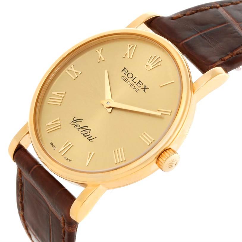 The Rolex Cellini 5115 Men
s Yellow Gold Champagne Dial 5115 Men
s Yellow Gold Champagne Dial watch is shown at an angle highlighting its gold dial, Roman numerals, and brown leather strap.