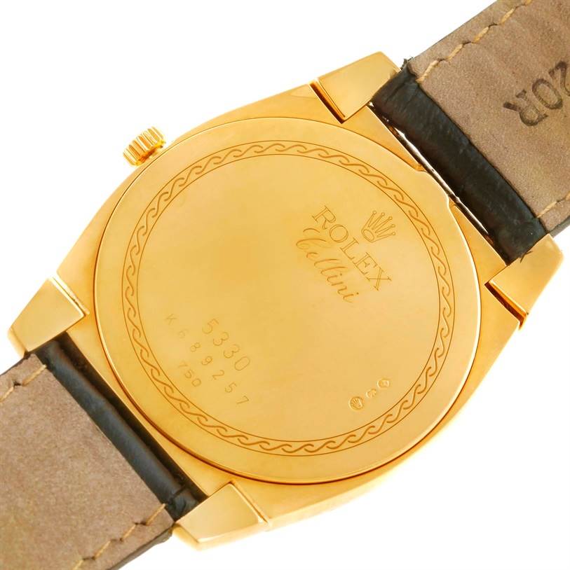The image shows the back case of a Rolex Cellini 5330 Men's Yellow Gold White Dial 5330 Men's Yellow Gold White Dial watch, including part of its leather strap and golden crown.