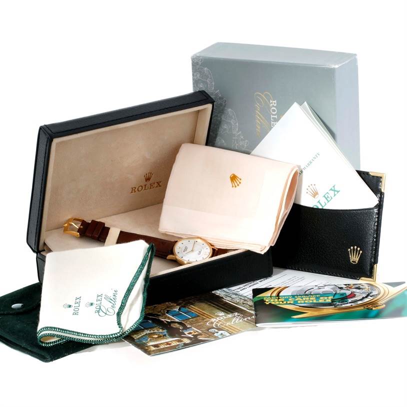 The image shows a Rolex Cellini 5115 Men
s Yellow Gold Silver Dial 5115 Men
s Yellow Gold Silver Dial watch with its box, papers, and accessories from a slightly elevated angle.