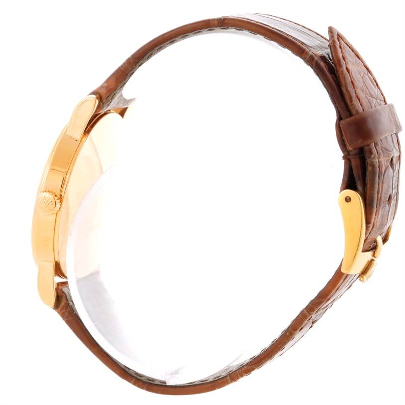 The image shows a side view of a Rolex Cellini 5115 Men
s Yellow Gold Beige Dial 5115 Men
s Yellow Gold Beige Dial watch with a brown leather strap and gold case.