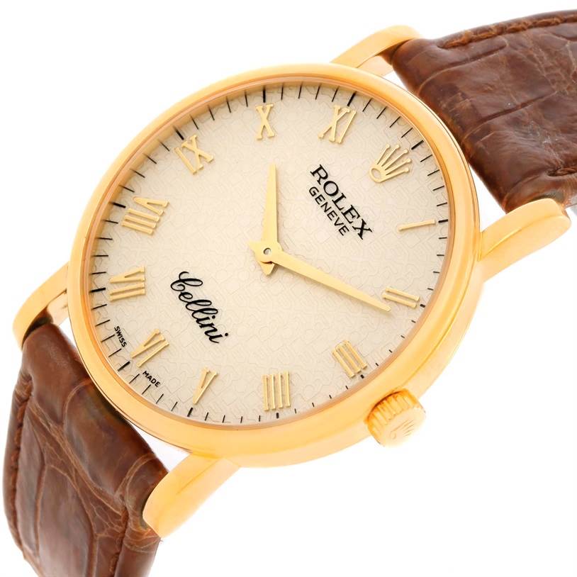 The image shows a close-up view of the Rolex Cellini 5115 Men
s Yellow Gold Beige Dial 5115 Men
s Yellow Gold Beige Dial watch
s face, case, crown, and leather strap at an angle.