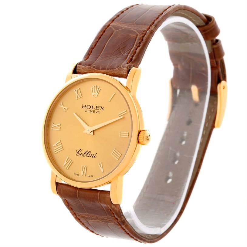 This image shows a Rolex Cellini 5115 Men
s Yellow Gold Champagne Dial 5115 Men
s Yellow Gold Champagne Dial watch from a three-quarter angle, featuring the face, bezel, and part of the brown leather strap.