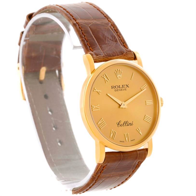 The Rolex Cellini 5115 Men
s Yellow Gold Champagne Dial 5115 Men
s Yellow Gold Champagne Dial watch is shown at a side angle, displaying its gold face, brown leather strap, and gold Roman numeral markers.