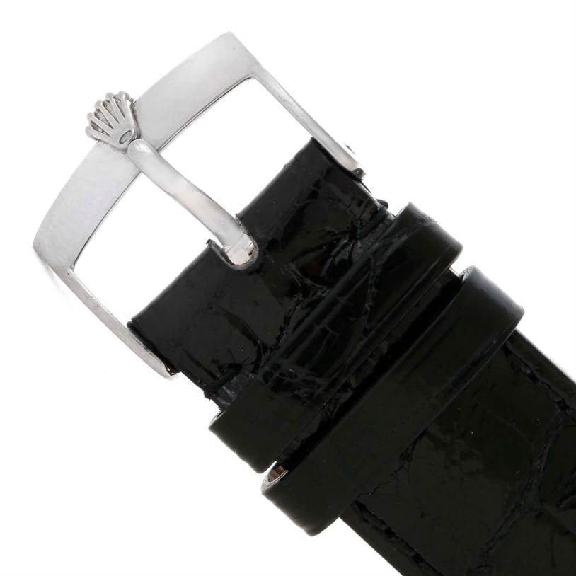 This image shows a close-up of the black leather strap and silver buckle of a Rolex Cellini 4233 Men
s White Gold White Dial 4233 Men
s White Gold White Dial watch from the top angle.