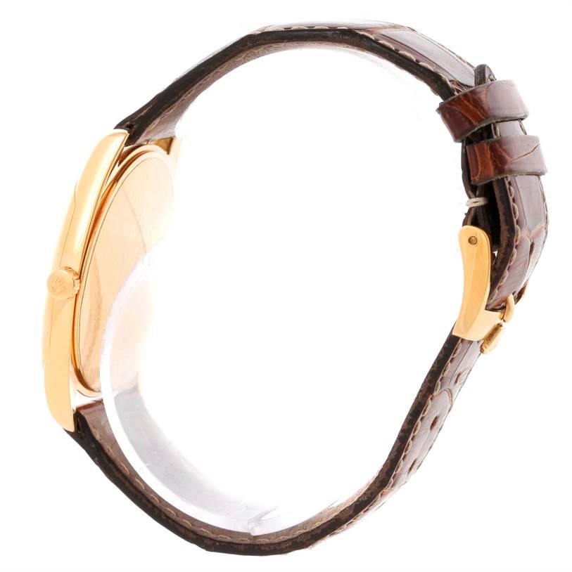 This image shows a Rolex Cellini 4233 Men's Yellow Gold White Dial 4233 Men's Yellow Gold White Dial watch from a side angle, highlighting its gold case, crown, and brown leather strap.