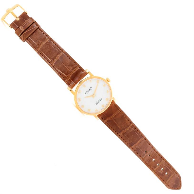 This Rolex Cellini 5115 Men
s Yellow Gold Mother of Pearl Dial 5115 Men
s Yellow Gold Mother of Pearl Dial watch is shown flat from an overhead angle, featuring its white dial, gold case, and brown leather strap.