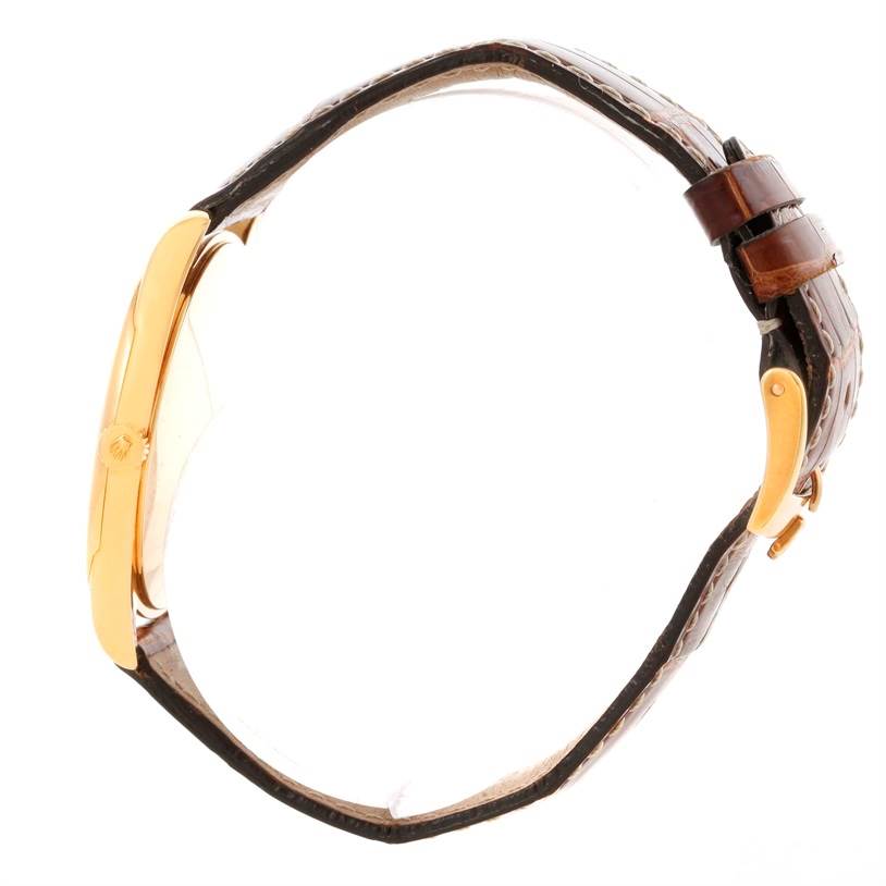 The side view of the Rolex Cellini 4233 Men's Yellow Gold White Dial 4233 Men's Yellow Gold White Dial watch shows the crown, case, and leather strap with a buckle.