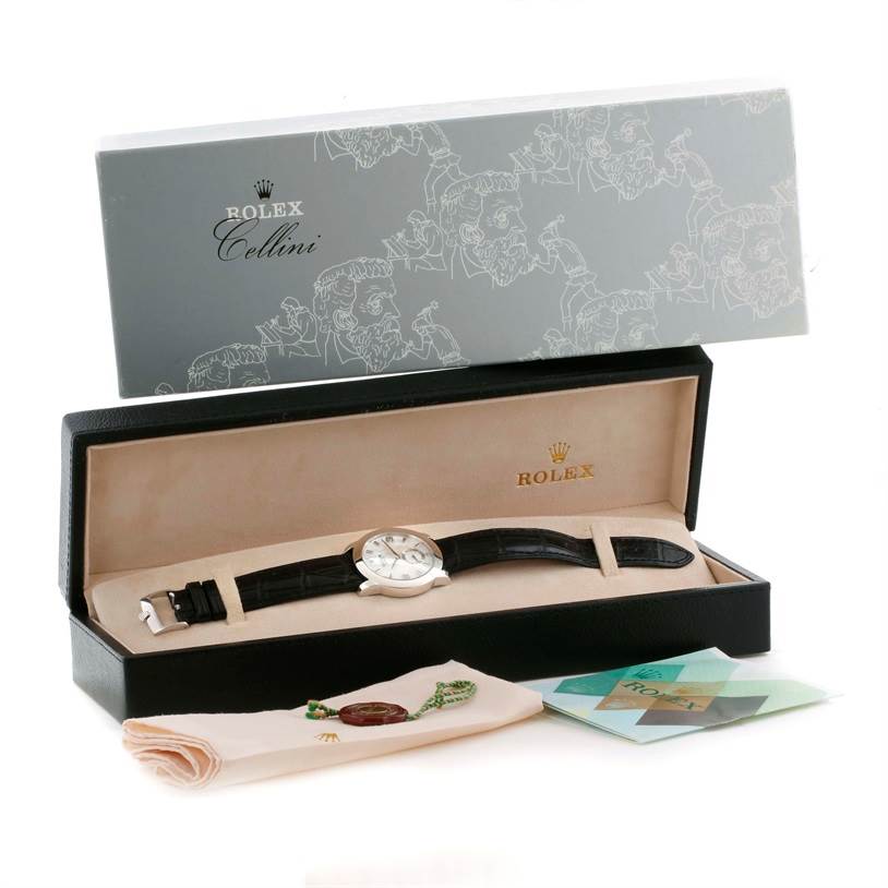 The Rolex Cellini 5240 Men
s Platinum Mother of Pearl Dial 5240 Men
s Platinum Mother of Pearl Dial watch is displayed in its box with a cleaning cloth and warranty card alongside the packaging.