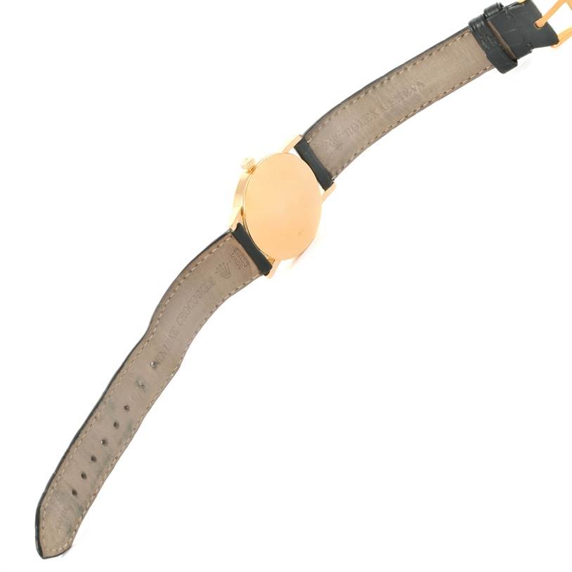 The image shows the back side of the Rolex Cellini 5115 Yellow Gold Mother of Pearl Dial 5115 Yellow Gold Mother of Pearl Dial watch, including its leather strap and gold case.