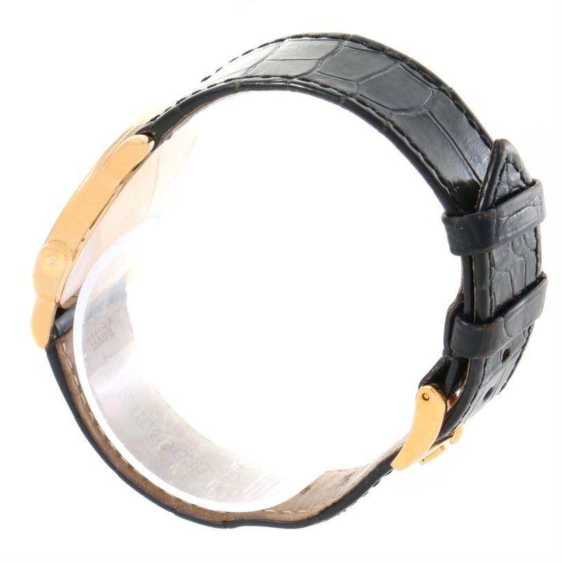 This image shows a side view of a Rolex Cellini 5115 Yellow Gold Mother of Pearl Dial 5115 Yellow Gold Mother of Pearl Dial watch with its black leather strap and gold buckle clasp.