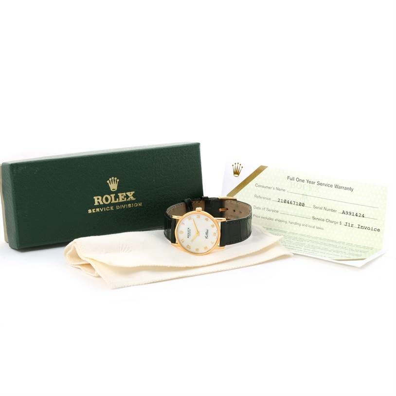 The image shows a Rolex Cellini 5115 Yellow Gold Mother of Pearl Dial 5115 Yellow Gold Mother of Pearl Dial watch, warranty card, box, and cleaning cloth from an angled perspective.