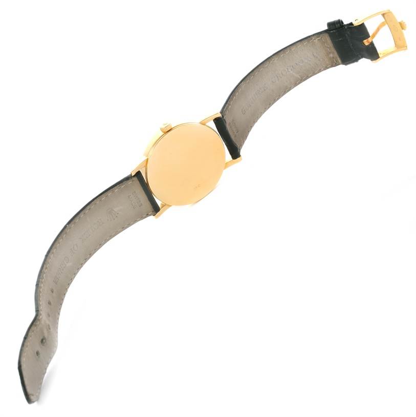 The image shows the back case and leather straps of a Rolex Cellini 5115 Yellow Gold Black Dial 5115 Yellow Gold Black Dial watch from a top-down angle.