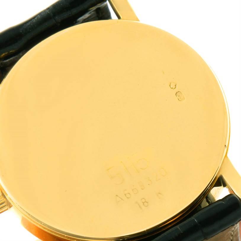 The image shows the back of a Rolex Cellini 5115 Yellow Gold Black Dial 5115 Yellow Gold Black Dial watch, highlighting its gold case and inscriptions.