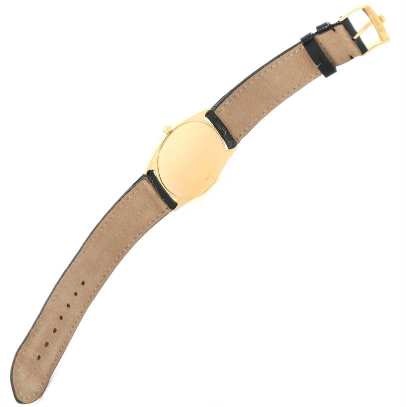 This image shows the back view of a Rolex Cellini 4233 Yellow Gold White Dial 4233 Yellow Gold White Dial watch with a gold case and a leather strap.