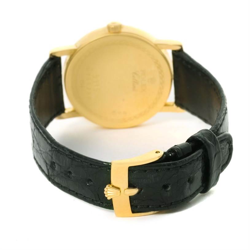 This image shows the back of a Rolex Cellini 5115 Men's Yellow Gold Champagne Dial 5115 Men's Yellow Gold Champagne Dial watch, highlighting its gold back case and black leather strap with a gold buckle.