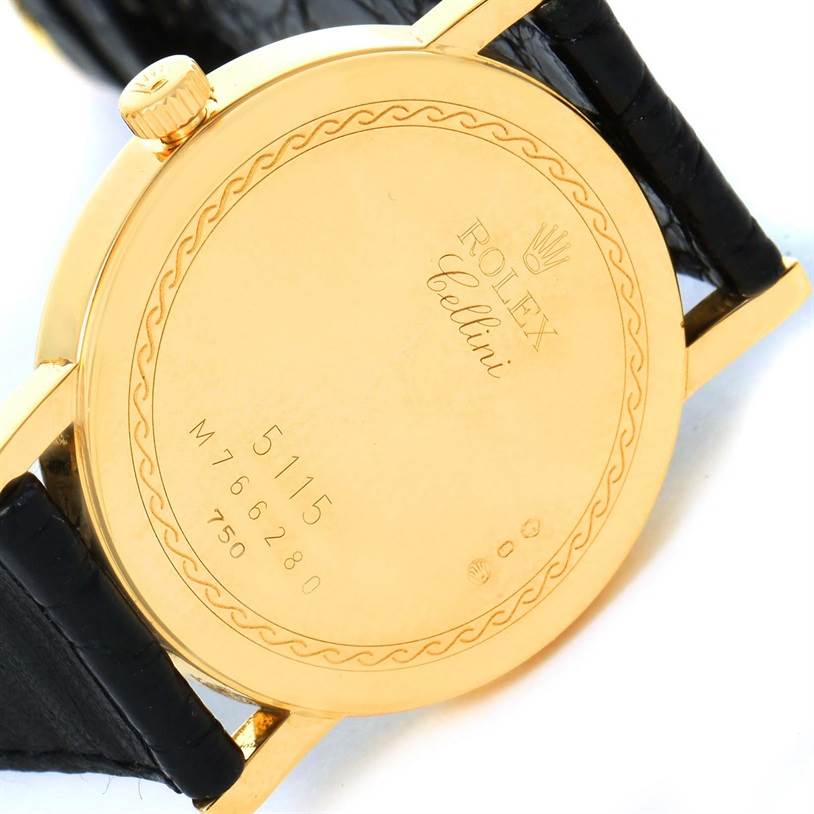 The image shows the back case and part of the crown of a Rolex Cellini 5115 Men's Yellow Gold Champagne Dial 5115 Men's Yellow Gold Champagne Dial model watch, including its inscriptions and serial numbers.