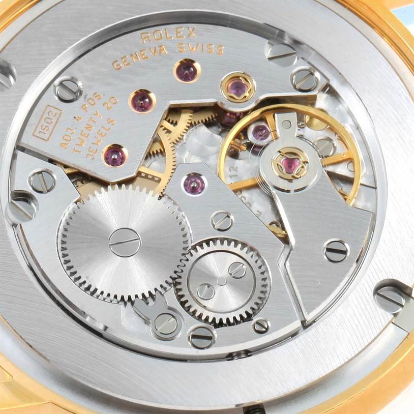 The image shows a detailed view of the movement mechanism inside a Rolex Cellini 5115 Men
s Yellow Gold Champagne Dial 5115 Men
s Yellow Gold Champagne Dial watch, highlighting gears and jewels.