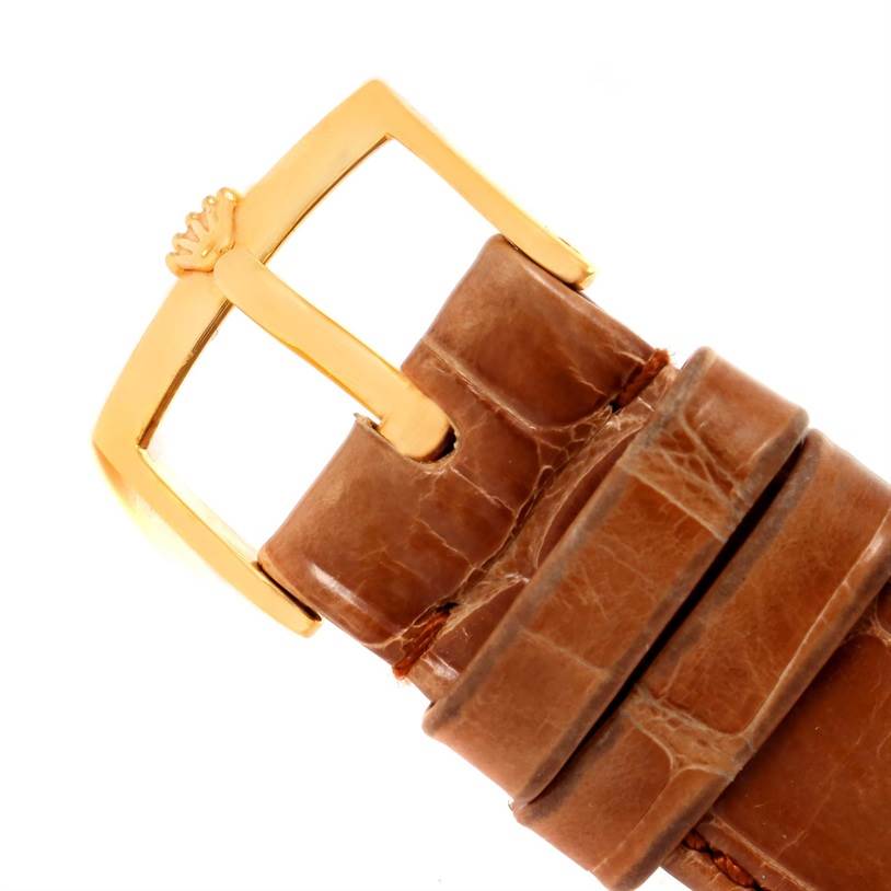 The image shows a close-up of the buckle and part of the leather strap of a Rolex Cellini 5115 Men
s Yellow Gold Champagne Dial 5115 Men
s Yellow Gold Champagne Dial watch.