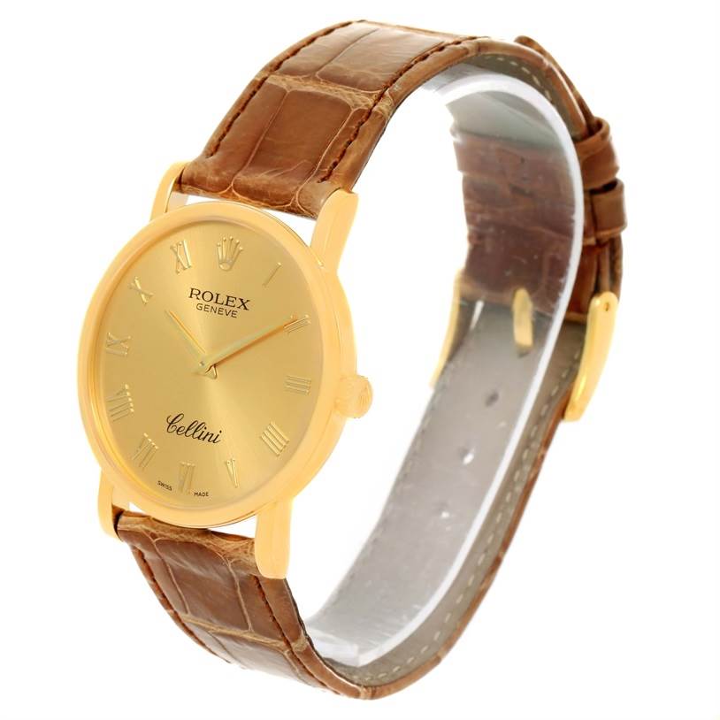 The image shows a Rolex Cellini 5115 Men
s Yellow Gold Champagne Dial 5115 Men
s Yellow Gold Champagne Dial watch at a slight angle, showcasing its gold case, brown leather strap, and gold dial with Roman numerals.