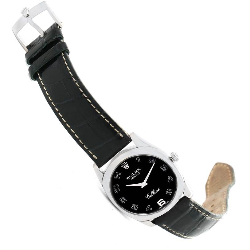 The image shows a tilted view of a Rolex Cellini 4233 Men
s White Gold Black Dial 4233 Men
s White Gold Black Dial watch, including the face, crown, and leather strap with a buckle.