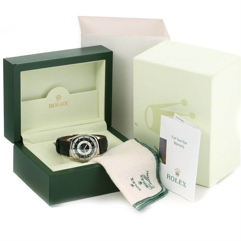 The Rolex Cellini 4243 Men's White Gold Black Dial 4243 Men's White Gold Black Dial watch is shown in its open box at an angle, along with its warranty card, cloth, and outer packaging.