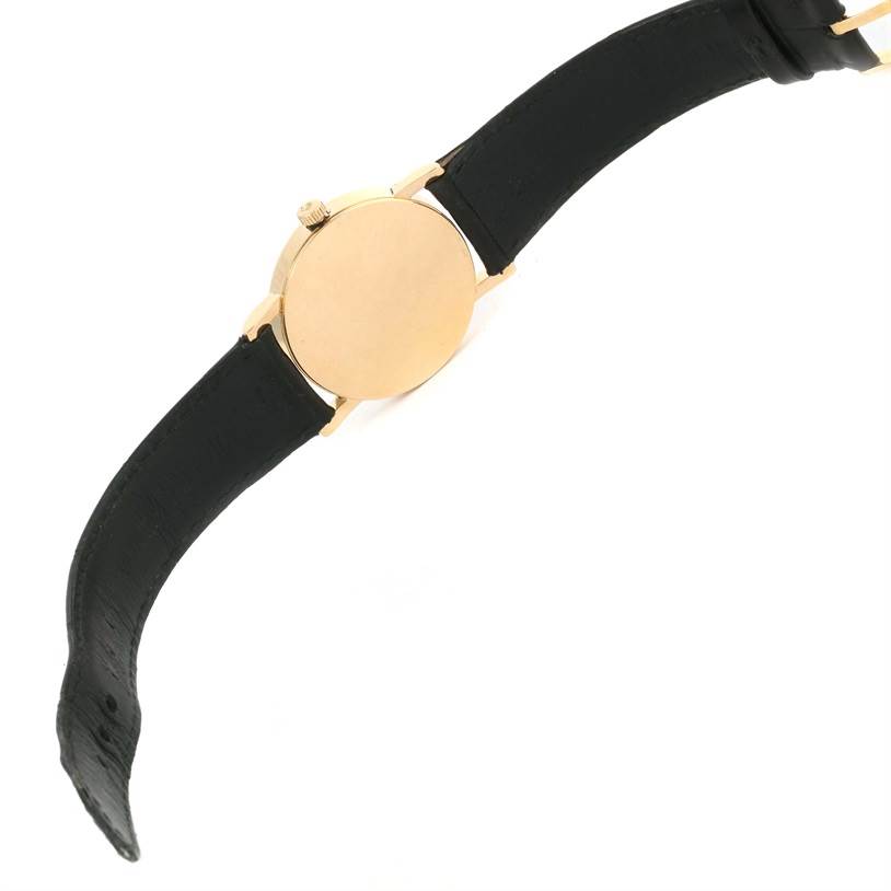 This image shows the back view of the Rolex Cellini 5115 Yellow Gold Silver Dial 5115 Yellow Gold Silver Dial watch, highlighting its gold case and black leather strap.