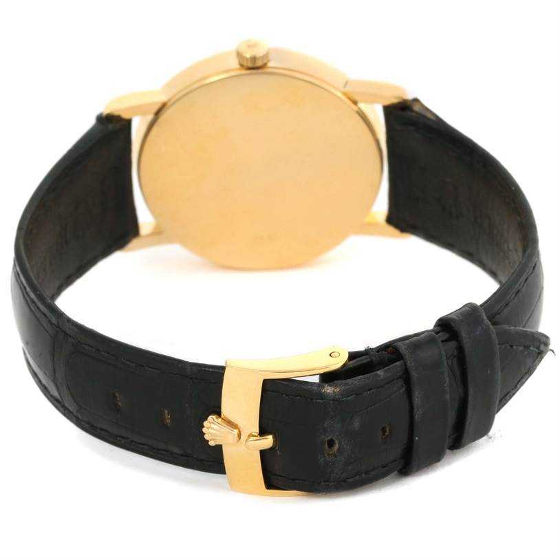 The image shows the back view of a Rolex Cellini 5115 Yellow Gold Silver Dial 5115 Yellow Gold Silver Dial watch highlighting its black leather strap and gold clasp.