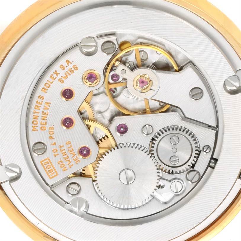 This image shows the intricate internal mechanism of a Rolex Cellini 5115 Yellow Gold Silver Dial 5115 Yellow Gold Silver Dial watch, viewed from the back, highlighting gears and movement components.