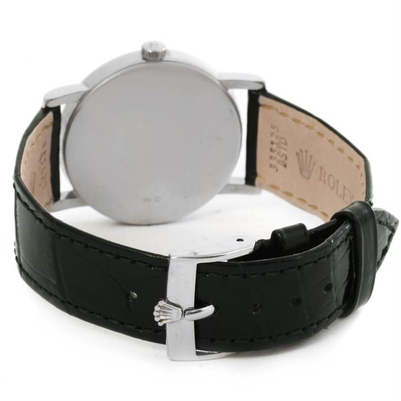 The image shows the back view of a Rolex Cellini 5115 White Gold Silver Dial 5115 White Gold Silver Dial watch with its black leather strap and clasp featuring the Rolex logo.