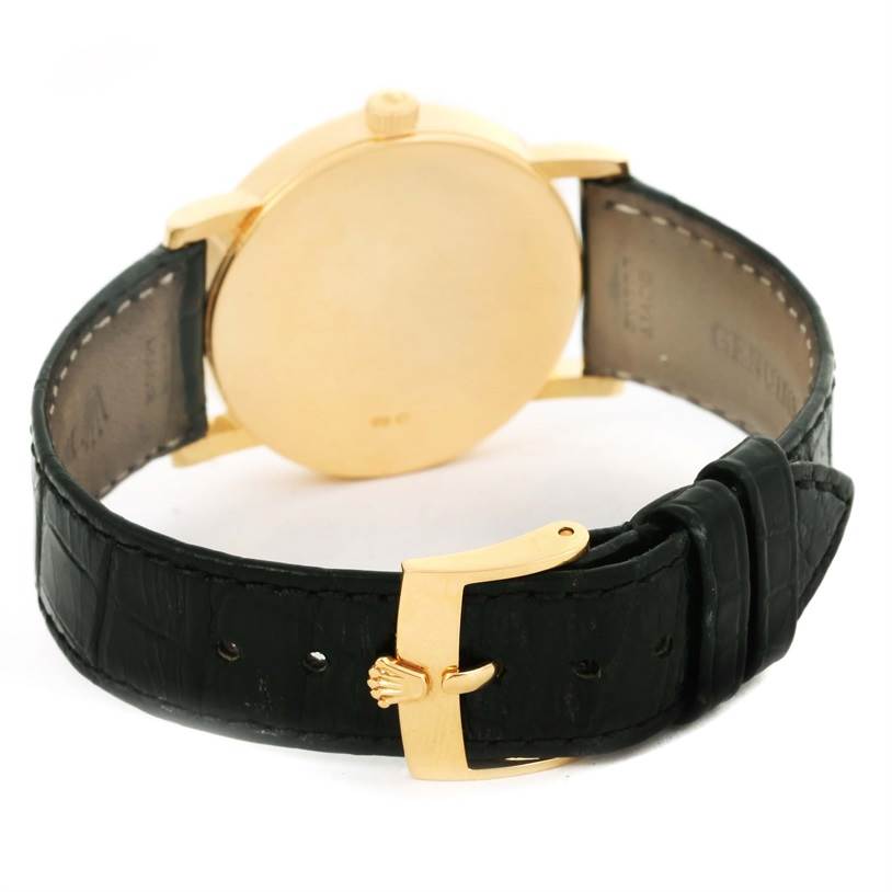 The image shows the back view of a Rolex Cellini 5115 Men's Yellow Gold Black Dial 5115 Men's Yellow Gold Black Dial watch, highlighting the gold case and black leather strap with a gold buckle.