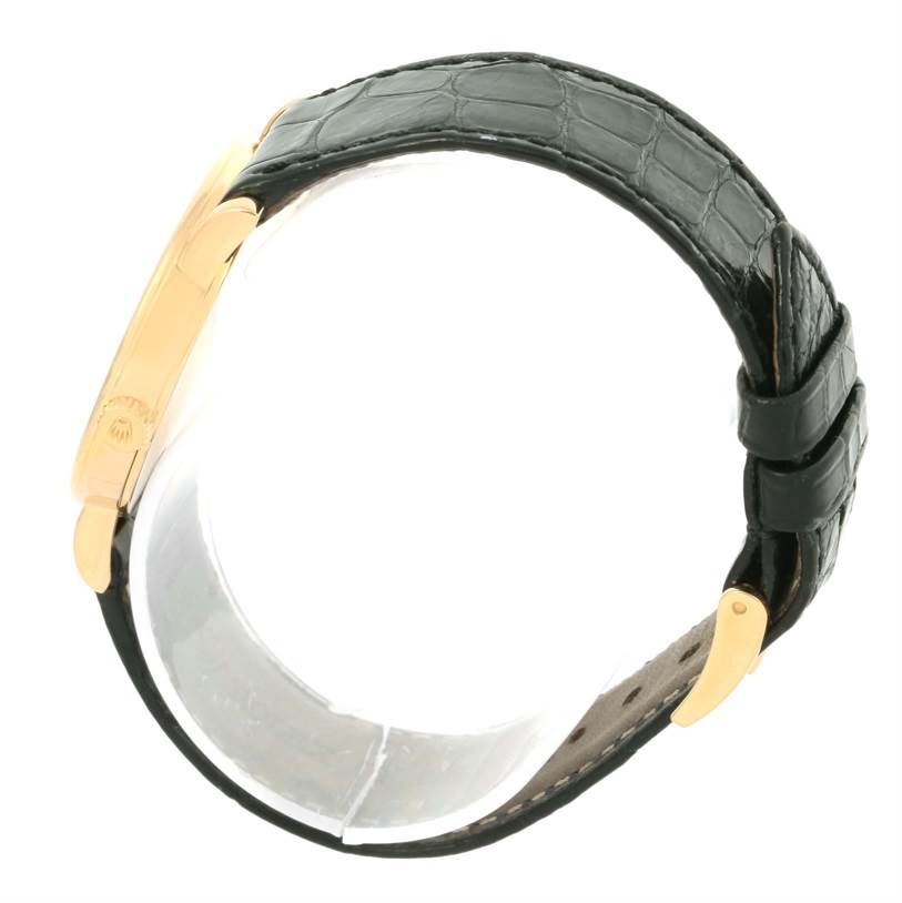 The image shows a side view of a Rolex Cellini 5115 Men's Yellow Gold Black Dial 5115 Men's Yellow Gold Black Dial watch, highlighting its leather strap and golden clasp.