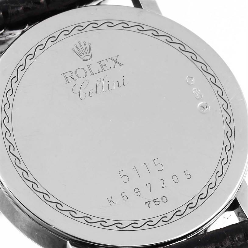 The image shows the back case of a Rolex Cellini 5115 Men's White Gold Silver Dial 5115 Men's White Gold Silver Dial model watch, featuring engraved branding, serial numbers, and decorative detailing.