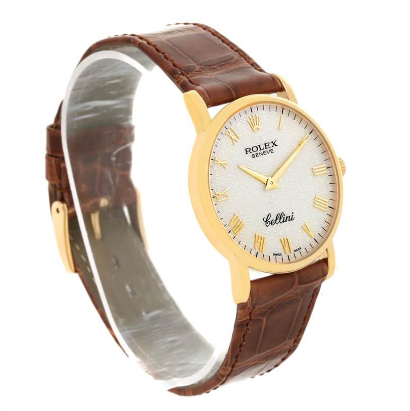 The image shows a side angle of a Rolex Cellini 5115 Men
s Yellow Gold Beige Dial 5115 Men
s Yellow Gold Beige Dial watch, highlighting its brown leather strap, gold case, and white dial with Roman numerals.