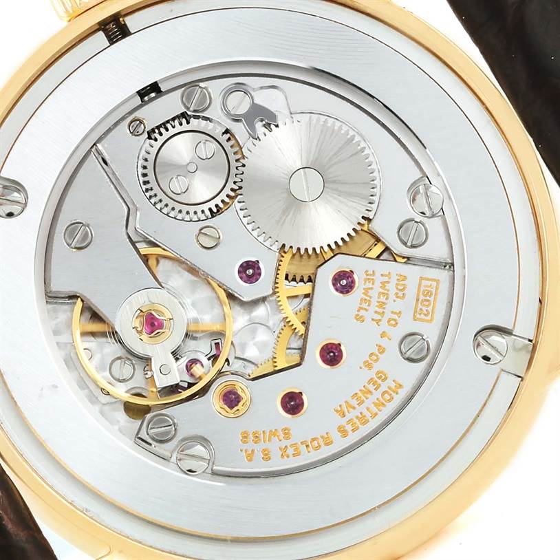 The image shows the back view of the Rolex Cellini 5116 Men
s Yellow Gold Silver Dial 5116 Men
s Yellow Gold Silver Dial model, highlighting its internal mechanical parts and gears.