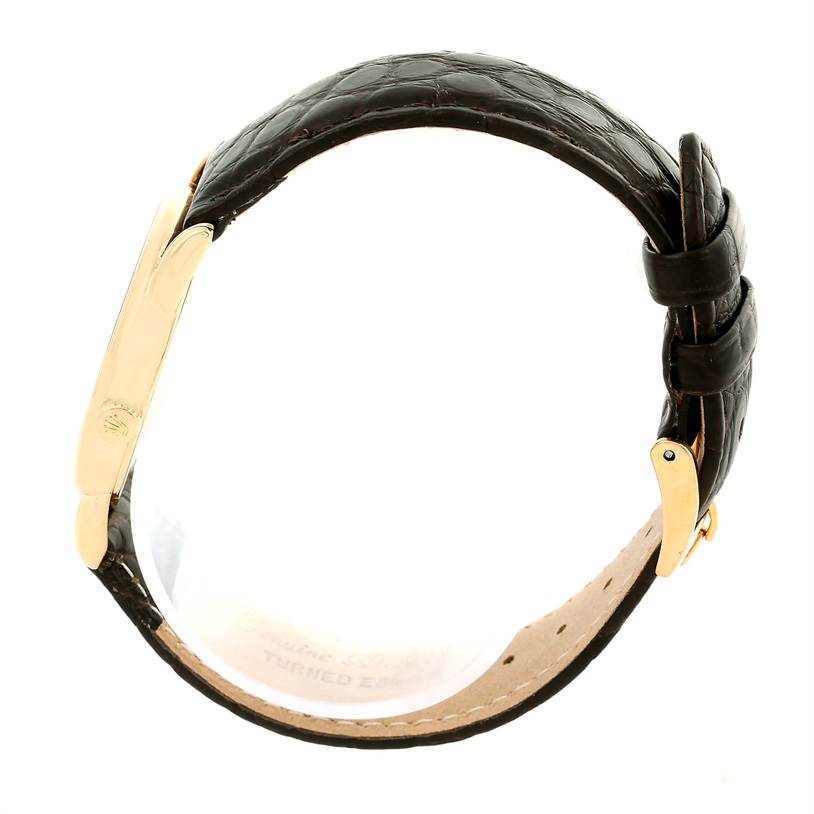 The image shows a side view of the Rolex Cellini 5116 Men
s Yellow Gold Silver Dial 5116 Men
s Yellow Gold Silver Dial watch, focusing on its leather strap and gold clasp.