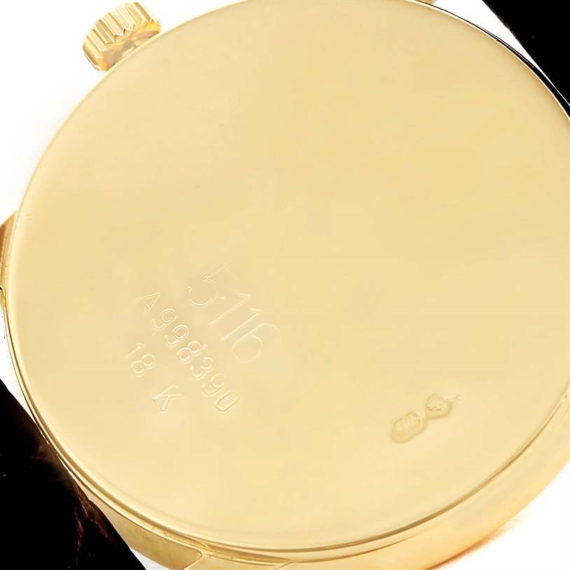 The image shows the back case and crown of a Rolex Cellini 5116 Men
s Yellow Gold Silver Dial 5116 Men
s Yellow Gold Silver Dial model watch, highlighting its serial number and 18K gold marking.