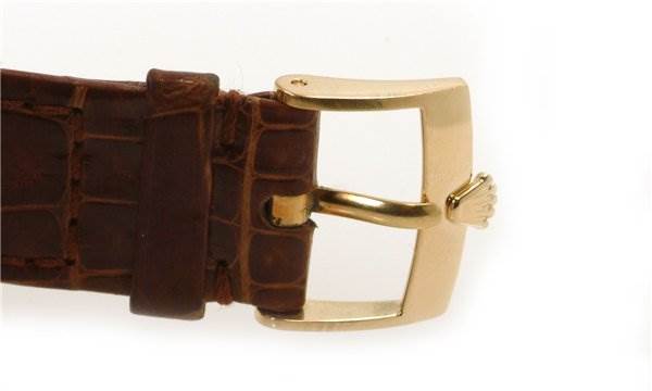 The image shows a close-up of the brown leather strap and gold buckle of a Rolex Cellini 5115 Men's Yellow Gold Silver Dial 5115 Men's Yellow Gold Silver Dial watch.