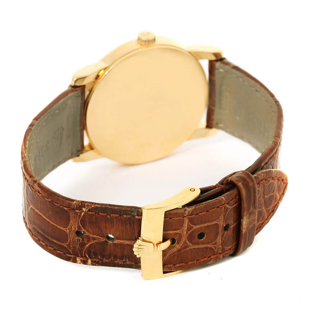 The image shows the back view of a Rolex Cellini 5116 Men's Yellow Gold Grey Dial 5116 Men's Yellow Gold Grey Dial watch with a gold case and brown leather strap.