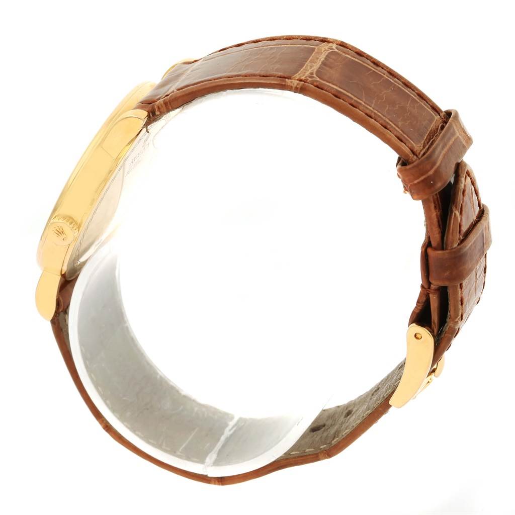 The image shows a side profile of a Rolex Cellini 5115 Men
s Yellow Gold Beige Dial 5115 Men
s Yellow Gold Beige Dial watch highlighting its gold case, brown leather strap, and buckles.