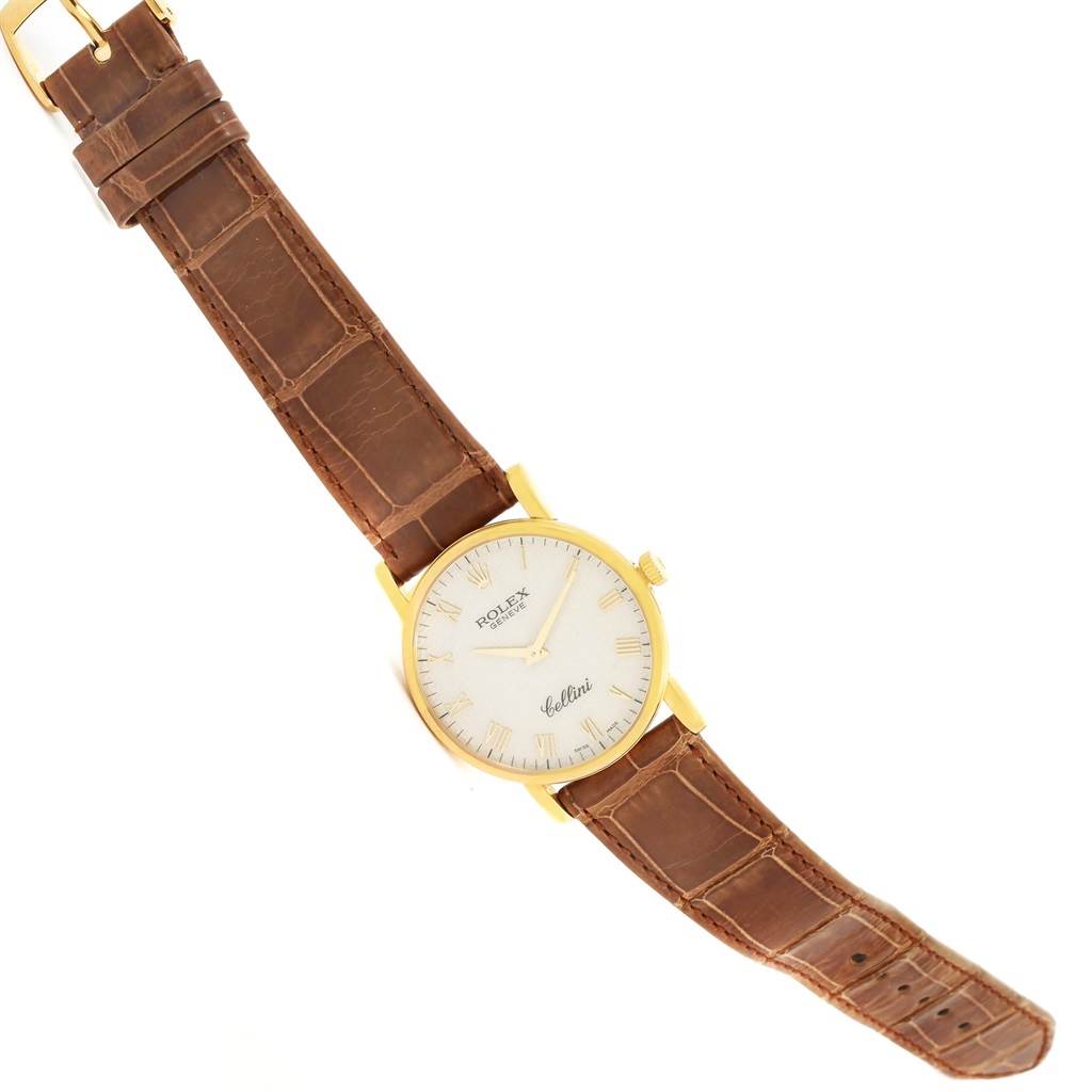 The image shows a Rolex Cellini 5115 Men
s Yellow Gold Beige Dial 5115 Men
s Yellow Gold Beige Dial watch at a slight diagonal angle, featuring a gold case, a white dial, and a brown leather strap.