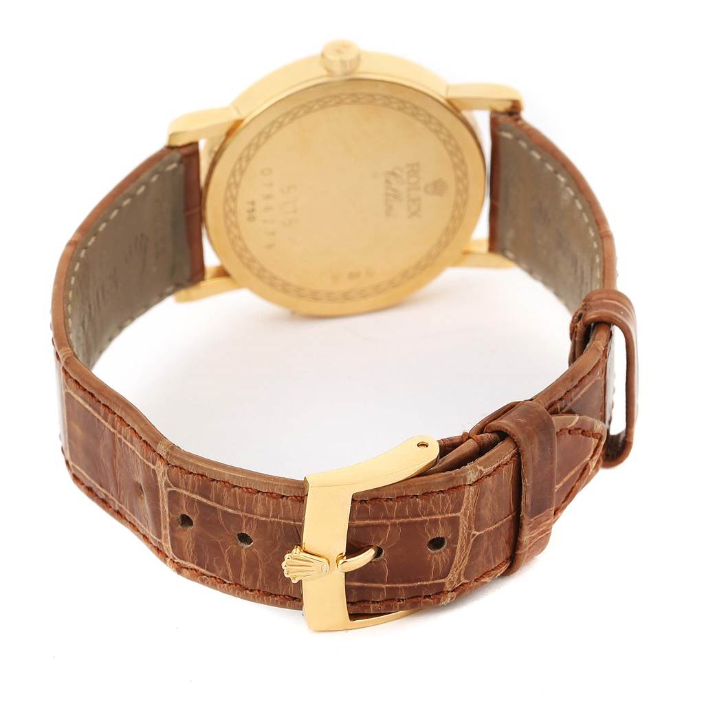 This image shows the back of a Rolex Cellini 5115 Men
s Yellow Gold Beige Dial 5115 Men
s Yellow Gold Beige Dial watch with a brown leather strap and a gold clasp.
