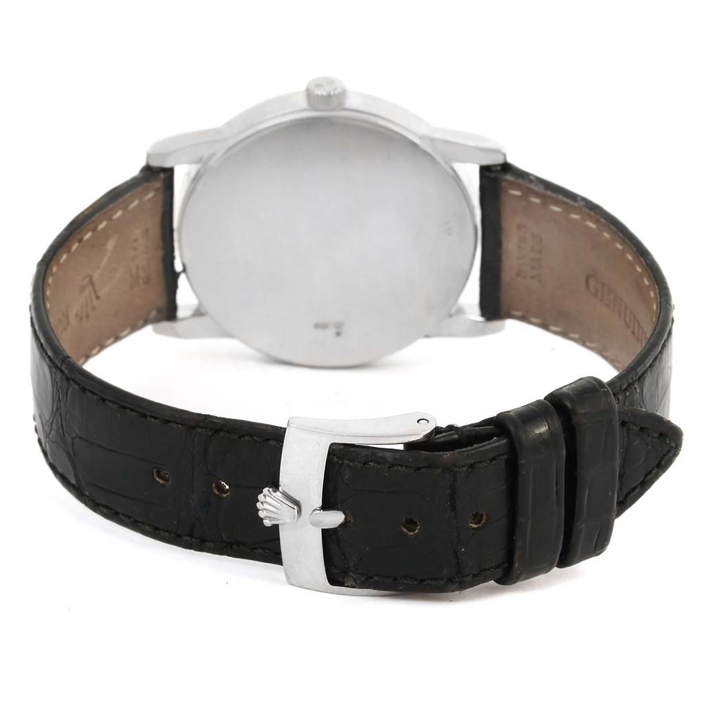 The image shows the back view of a Rolex Cellini 5116 Men
s White Gold Silver Dial 5116 Men
s White Gold Silver Dial watch, including the case, crown, and leather strap with a clasp.