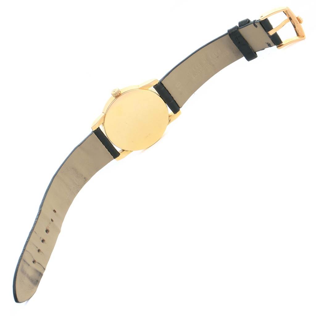 This is a Rolex Cellini 5116 Men's Yellow Gold Silver Dial 5116 Men's Yellow Gold Silver Dial watch shown from the back, displaying the gold case and black leather strap.