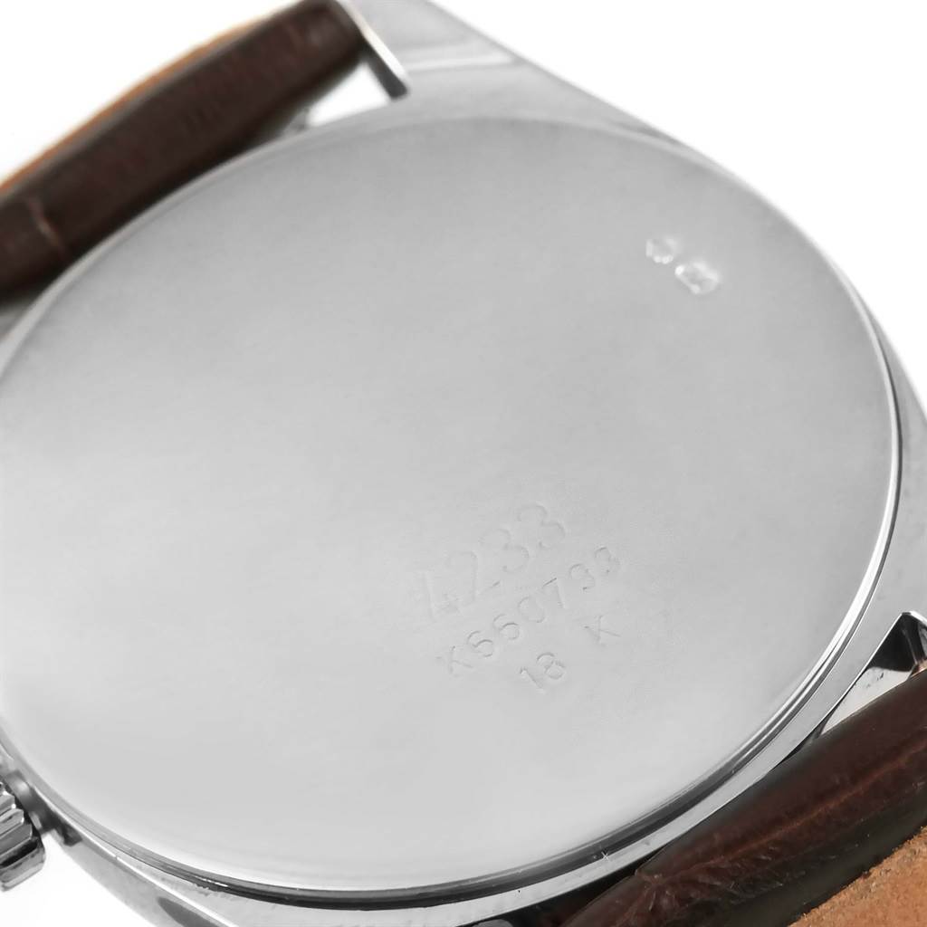 The image shows the back case and a portion of the leather strap of a Rolex Cellini 4233 Men
s White Gold Black Dial 4233 Men
s White Gold Black Dial watch.