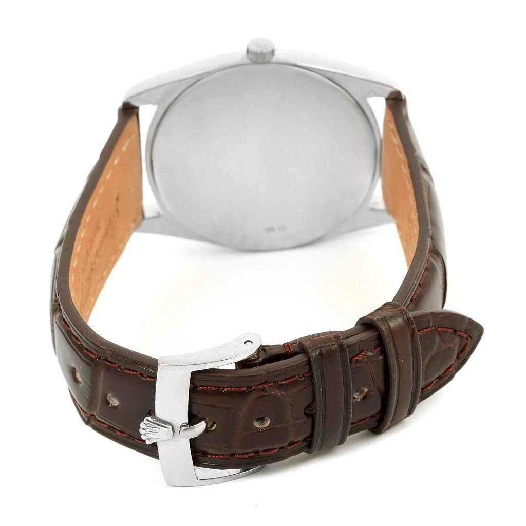 The image shows the back of a Rolex Cellini 4233 Men
s White Gold Black Dial 4233 Men
s White Gold Black Dial watch with a focus on its brown leather strap and buckle.