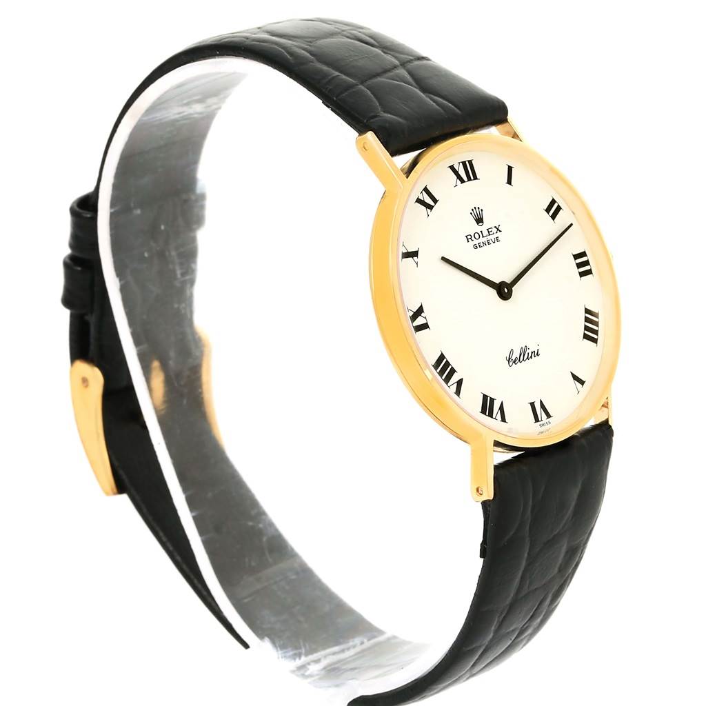 This is a side angle view of a Rolex Cellini 3833 Yellow Gold White Dial 3833 Yellow Gold White Dial watch showing its face, black leather strap, and gold case.