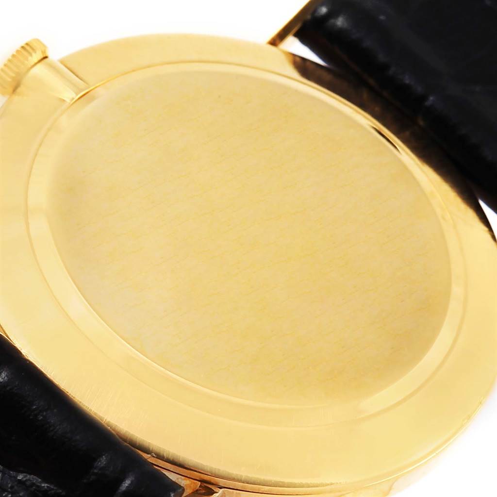 The image shows the back case of a Rolex Cellini 3833 Yellow Gold White Dial 3833 Yellow Gold White Dial watch, emphasizing its gold casing and part of the black leather strap.