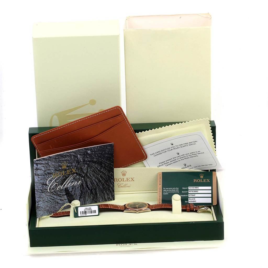 The image shows a Rolex Cellini 4233 Men
s White Gold Black Dial 4233 Men
s White Gold Black Dial watch and its accessories, including the box, warranty card, manual, and a polishing cloth.